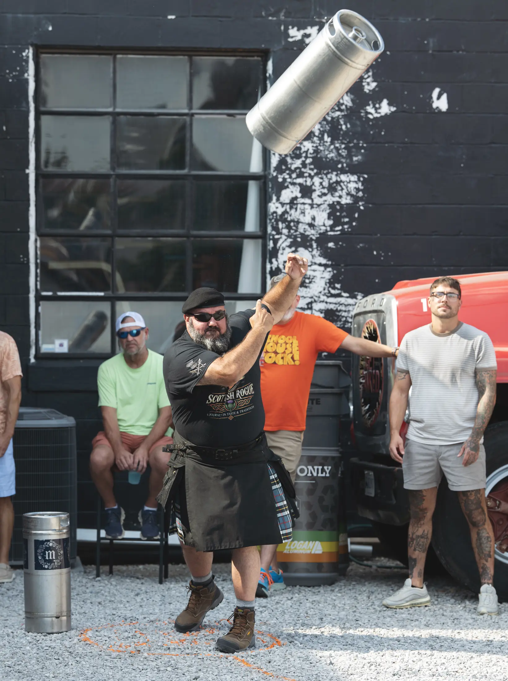 A guest tossing a keg outdoors during White Squirrel's Oktoberfest games